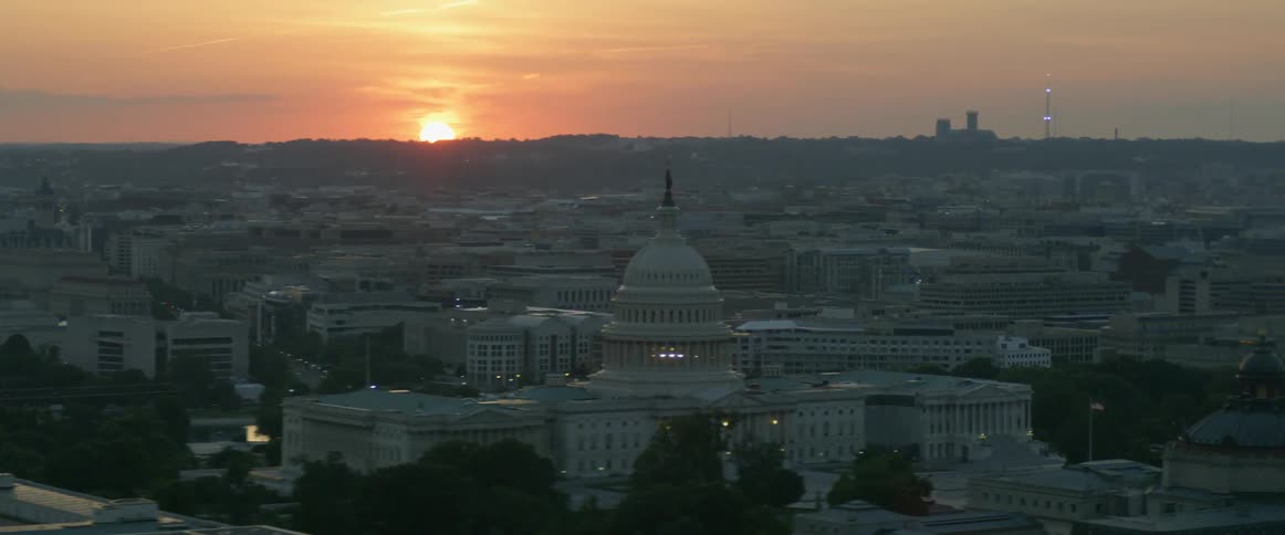 A capitol building is shown at sunset