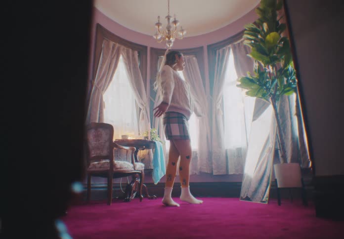 A woman spins and dances under the chandelier