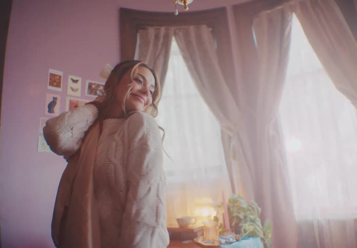 A woman is waving around a sheet of fabric