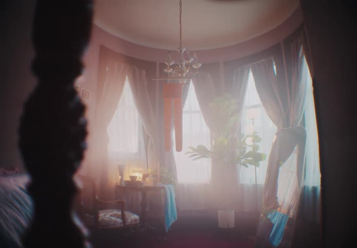 A room with four huge windows with large curtains and strong natural light coming from outside