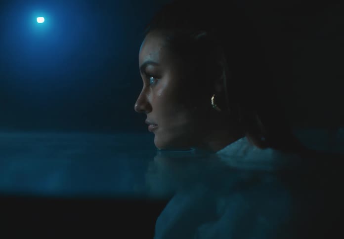 A woman is standing in the pool at night