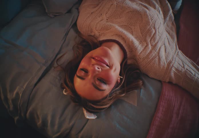 Happy woman lying down on the bed