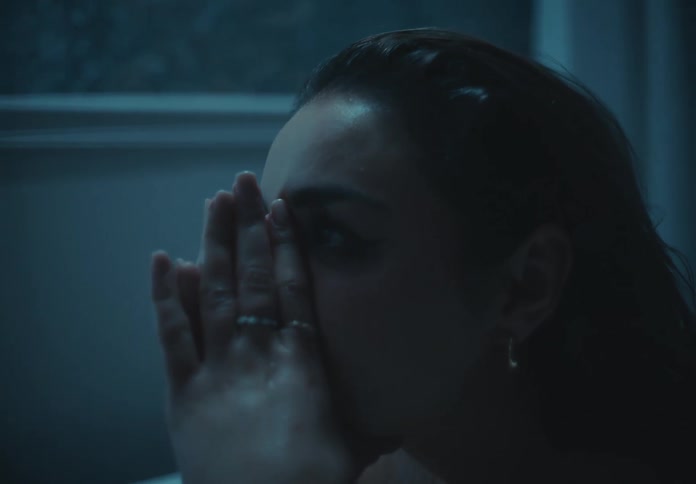 Woman with wet hair running her hand over her face