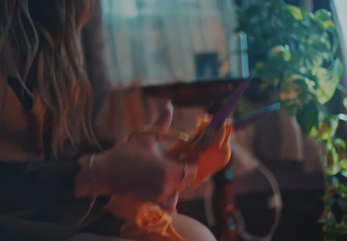 A person using scissors to tear and destroy a yellow piece of clothing