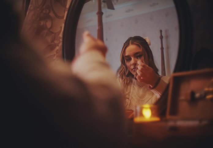 Woman sitting in front of a mirror sewing
