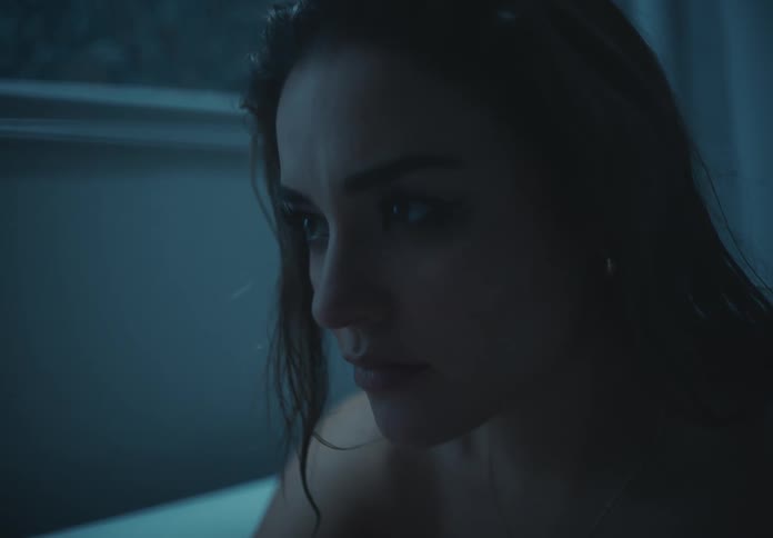 A woman in a bathtub thoughtful and serious