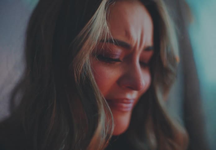 A woman is crying and cutting up clothing