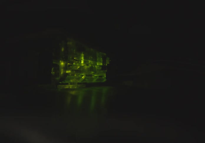 Internals of a light source shine red then green in a dark area