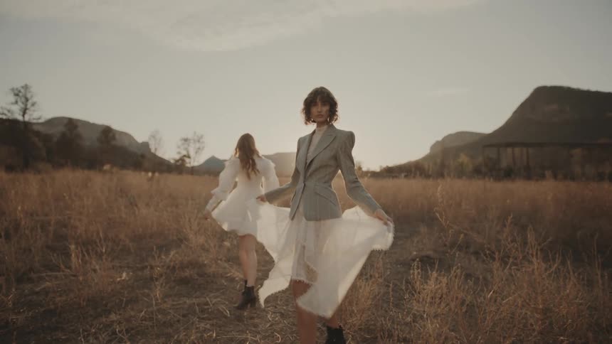 Two women turn around while walking on the field