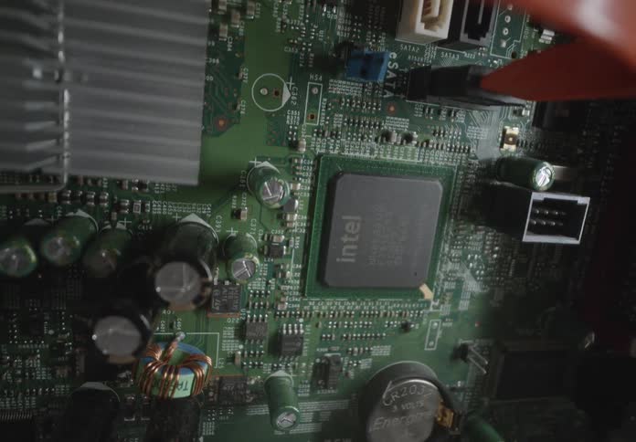 A closeup view of a computer motherboard with visible components including an intel chip capacitors heat sink and various connectors