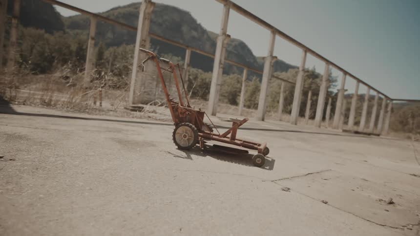 An old lawn mower outdoors under the sunlight