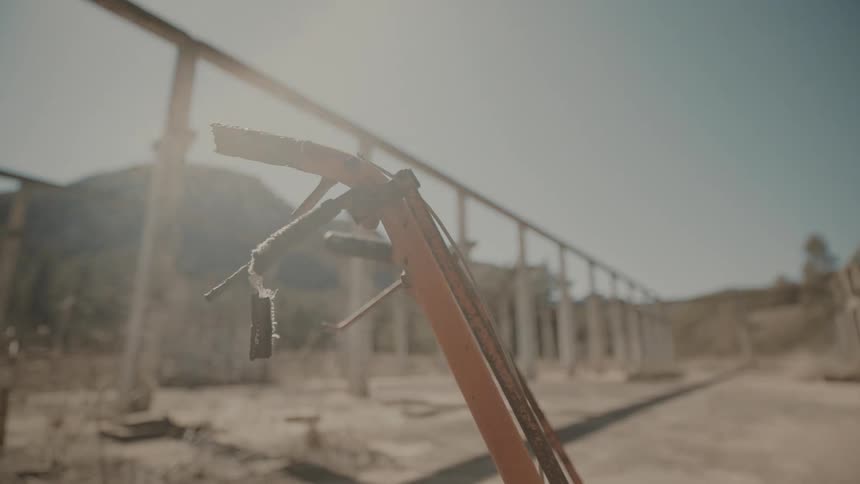 Rusty metal structure in an outdoor setting with mountains in the background
