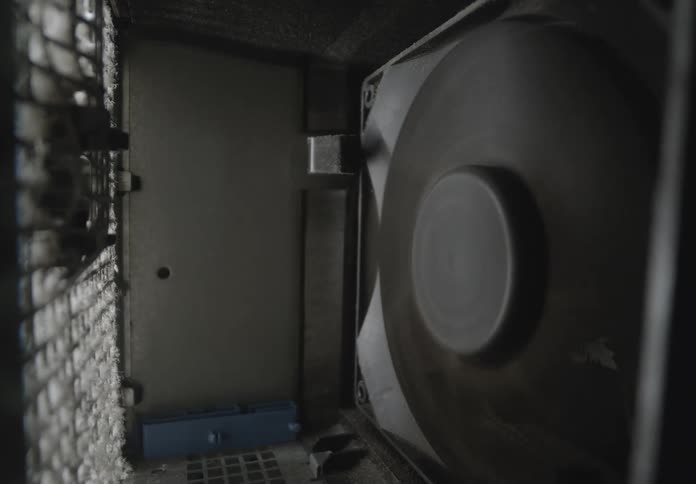 The computer fan is covered in dust as it spins