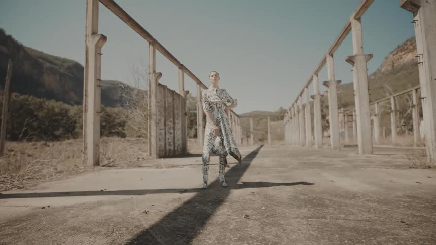 A woman outdoors doing a photoshoot in an abandoned building