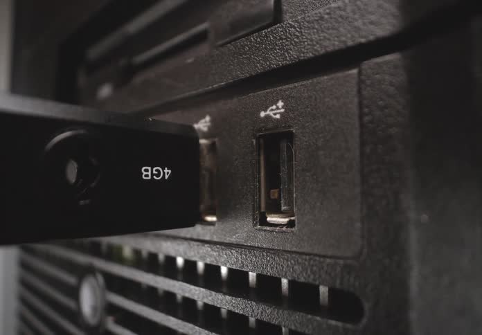 Pen drive being plugged into the usb port of a computer case