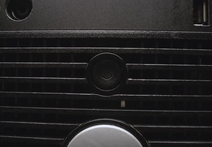 A closeup shot of a power button glowing green indicating that the device is turned on