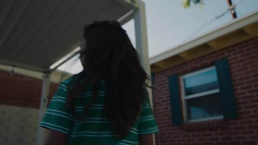 A girl walks to the play area in her yard