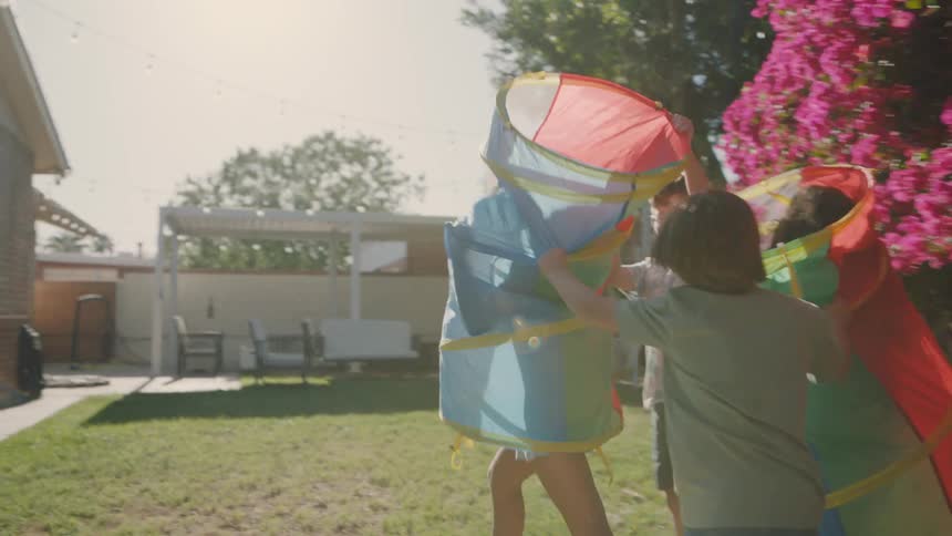 Children playing in a backyard with colorful bags