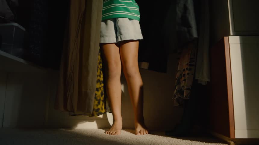 A boy hides in the closet during a game of hide and seek