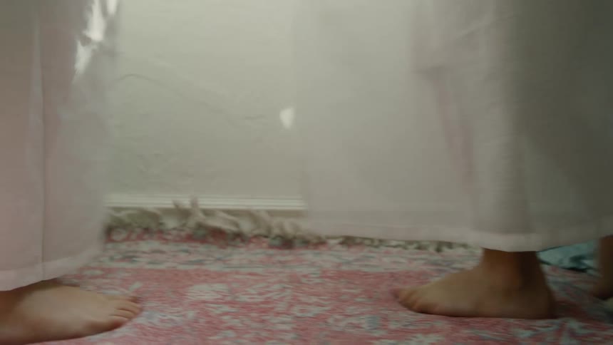 Two children spinning around playfully in a room