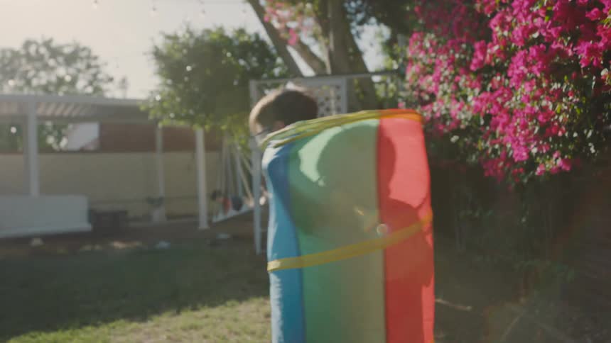 Two children playing and running through the backyard of a house