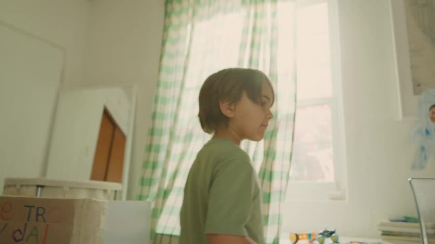 A young boy walks around indoors searching while playing hide and seek