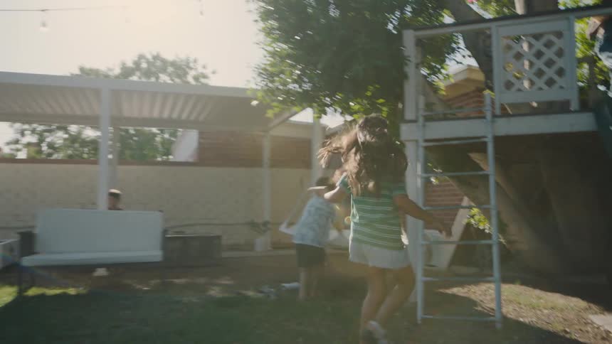 Children are running and playing and climbing in the yard