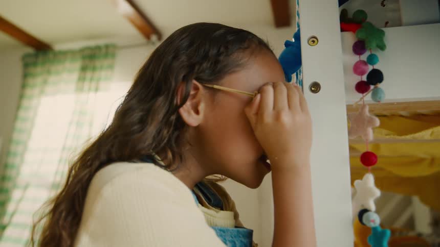Girl counts while leaning against the bunk beds before starting to search during a game of hide and seek