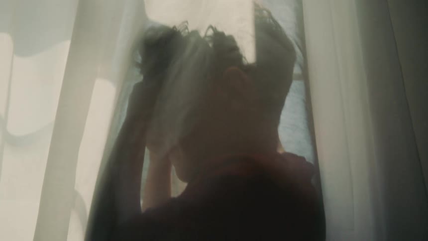 Two children hiding behind a curtain