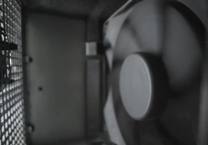 A closeup view of a mechanical component possibly a fan or ventilation system with a gridlike structure on the left side