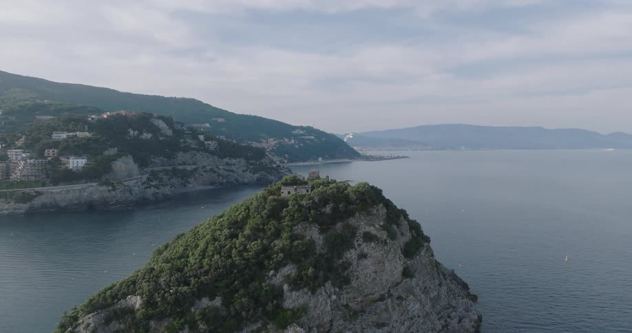 Seabirds soar above a coastal town perched on a highland surrounded by the vast ocean