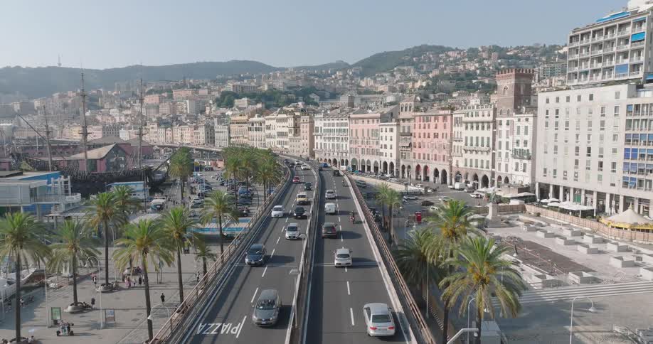 Aerial view of a highway with vehicle traffic surrounded by buildings and houses with mountains in the background