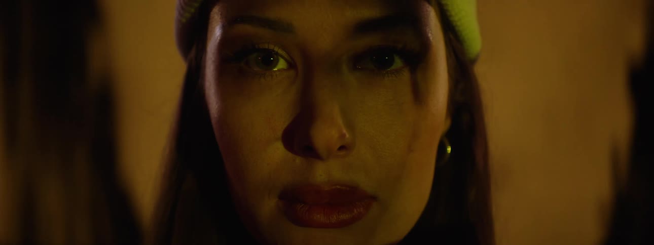 A woman standing still opens her eyes and stares straight ahead