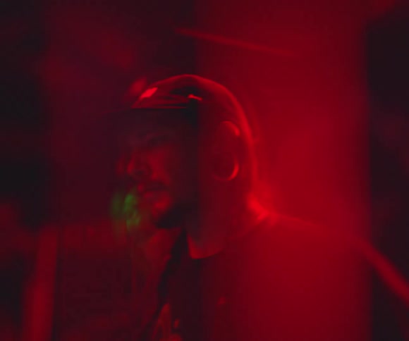 Two men dance in a room with red light