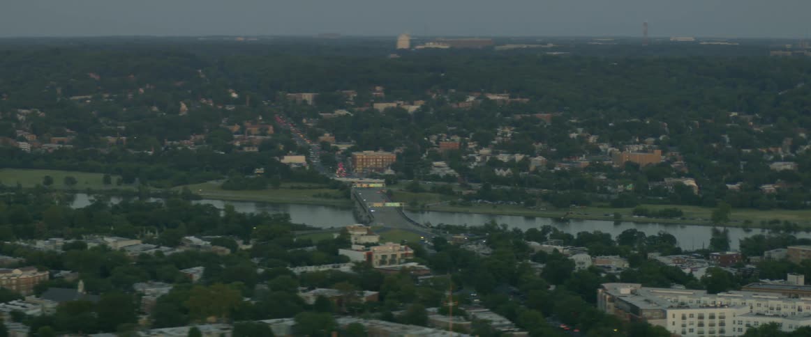 Bridge crosses river with city buildings on each bank