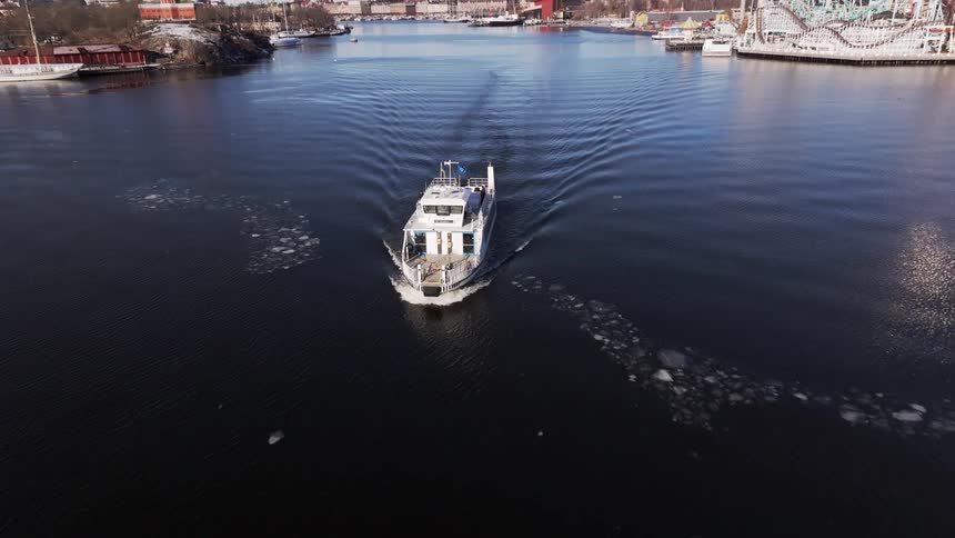 A yacht creates a wake as it leaves a marina