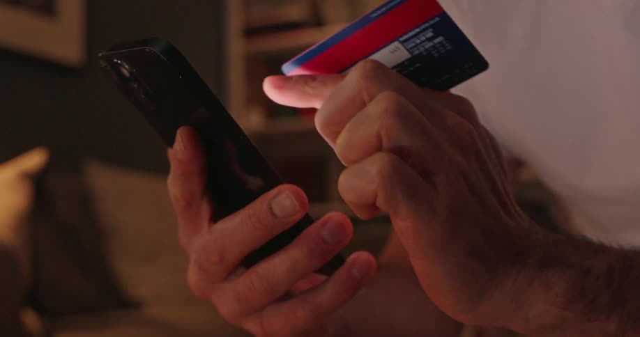 A man is putting his credit card into the phone