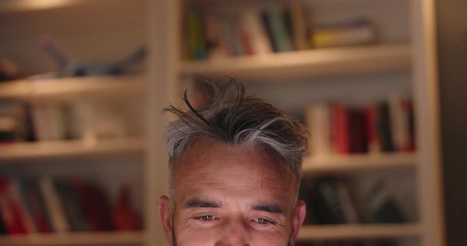 A man is sitting at home looking at a light