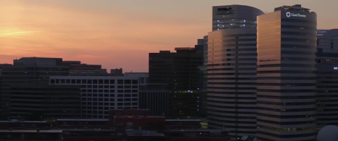 Tall buildings are reflecting the setting the sun