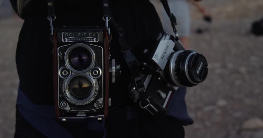 A photographer carrying many pieces of equipment