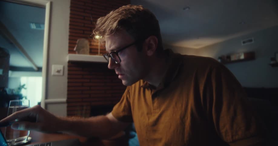Concentrated man checking data on a laptop and holding a calculator