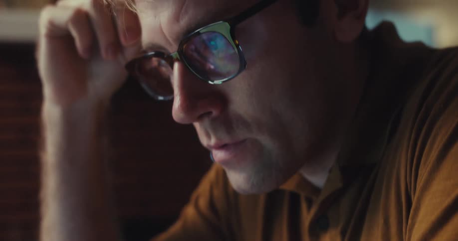 A man types on a laptop appearing deep in thought and slightly worried