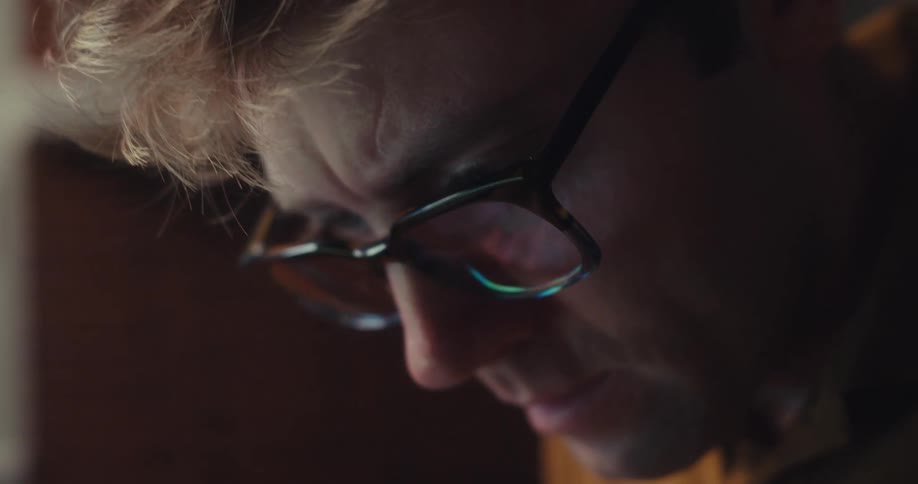 Focused man with glasses holding a calculator