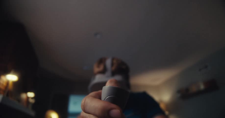 Man uses a virtual headset to play a game at home during the daytime