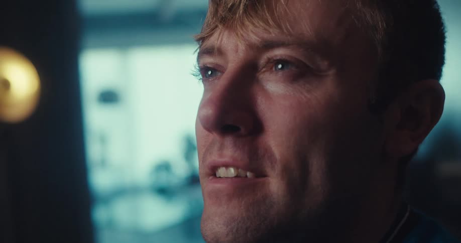 A man smiles warmly with his eyes closed expressing a serene and content moment