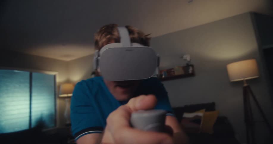 A man in a living room playing a virtual reality video game