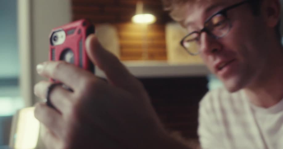 A man demonstrates his sunglasses recording feature while holding a rugged smartphone case close to the camera
