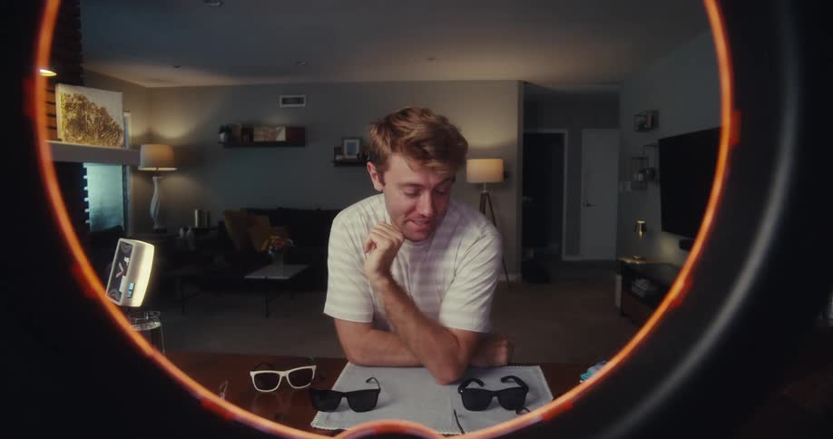 Male influencer sitting in his living room discusses eyeglasses and sunglasses