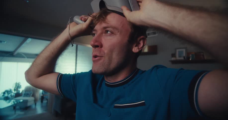 A man smiles joyfully as he removes a vr headset clearly thrilled after an immersive gaming experience