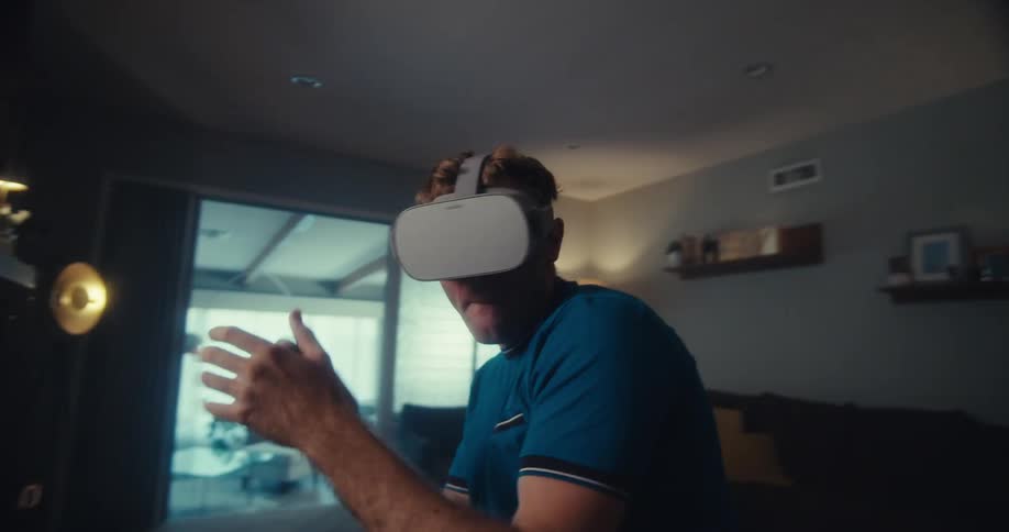 A man in a living room playing a virtual reality video game